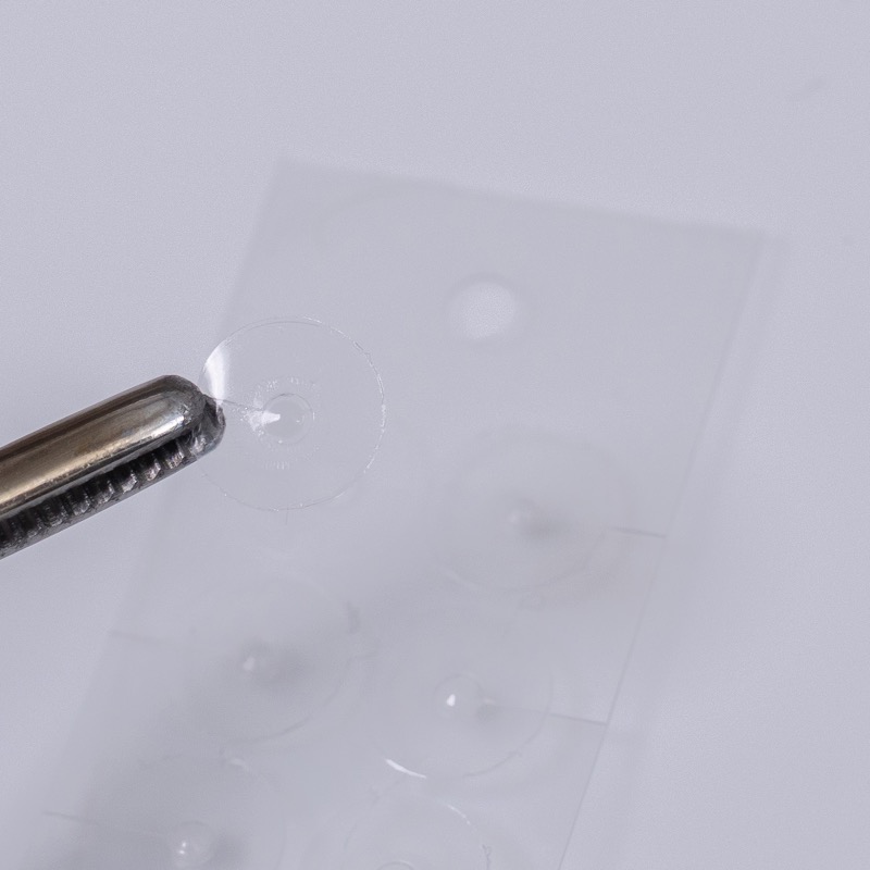 ピンセットで耳つぼジュエリーの粒をつまむ様子